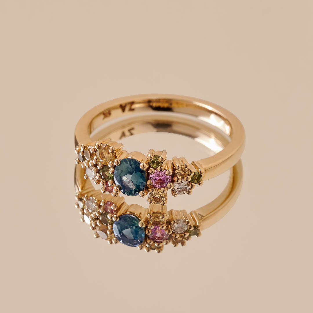 A sapphire and diamond cluster ring manufactured in yellow gold.