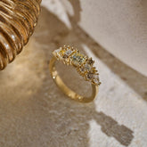 Solid gold Botanica Bouquet Ring, a cluster ring made up of a central yellow toned round natural diamond surrounded by smaller colourless, yellow and cognac diamonds photographed on an organic stone slab.