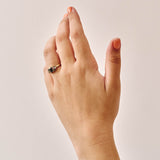 Handmade cluster engagement ring in 9ct yellow gold with a central emerald-cut green sapphire, surrounded by green, yellow, and pink sapphires and two natural diamonds in a floral-inspired design.