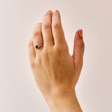 Handmade 9ct yellow gold trilogy ring featuring an emerald-cut green sapphire centre stone flanked by two round natural diamonds; elegant three-stone engagement ring design with timeless appeal.