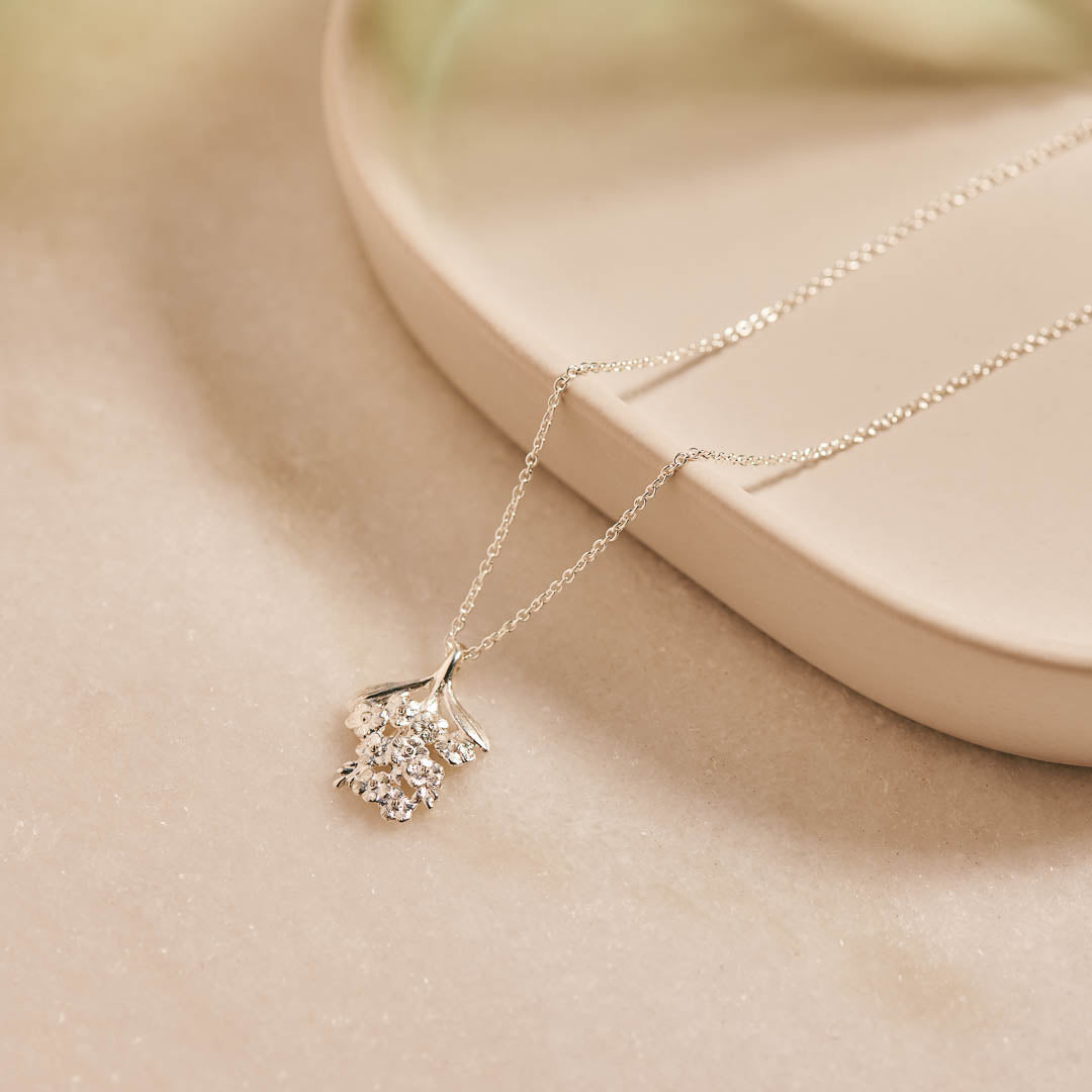 Forget-Me-Not flower inspired pendant with leaf detail, manufactured in sterling silver, and on a sterling silver rolo chain