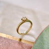 Gold ring with a diamond on a light background