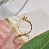 Gold ring with a diamond on a textured surface