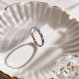 Luxury handmade platinum wedding ring featuring an intricate French pavé setting with baguette-cut natural diamonds and round light blue sapphires; a unique, high-end design perfect for weddings or milestone gifts.