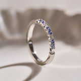 Luxury handmade platinum wedding ring featuring an intricate French pavé setting with baguette-cut natural diamonds and round light blue sapphires; a unique, high-end design perfect for weddings or milestone gifts.