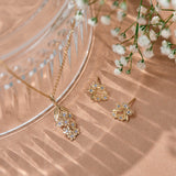 Forget-Me-Not flower inspired pendant with leaf detail, manufactured in 9ct yellow gold, set with light blue sapphires, and on a 9ct yellow gold rolo chain. Photographed with the Sapphire Forget-Me-Not studs