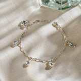 Silver miniature frog, citrus wedge, lemon, pear, and leaf jewellery charms on a silver paper clip chain.