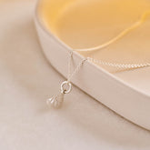 A miniature silver citrus wedge jewellery charm on a silver rolo chain.