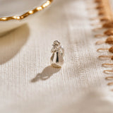 A miniature pear jewellery charm in silver.