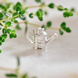 A miniature silver watering can jewellery charm.