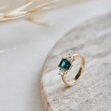 A striking blue emerald cut tourmaline flanked by two natural beautiful diamonds