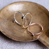 Three tube set black diamond rings in yellow gold, rose gold, and sterling silver