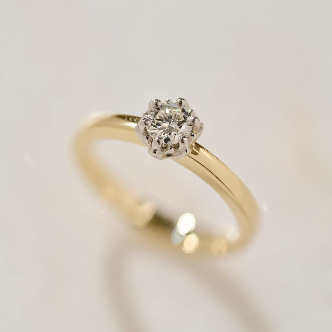 A close up photograph of the two tone Botanica Protea Ring showing the detail of the four claw setting holding the natural diamond and the solid platinum protea petals. 