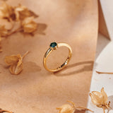 A round blue tourmaline set in a yellow gold ring