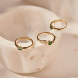 Three tourmaline and yellow gold rings photographed together