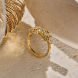 Solid gold Botanica Bouquet Ring, featuring a cluster yellow toned round natural diamonds, smaller natural colourless diamonds, yellow sapphires and cognac diamonds photographed on an organic stone slab. 