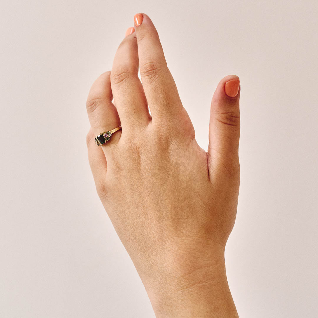 Handmade cluster engagement ring in 9ct yellow gold with a central emerald-cut green sapphire, surrounded by green, yellow, and pink sapphires and two natural diamonds in a floral-inspired design.