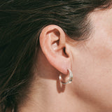 Sterling silver hoop earrings inspired by the shapes created by folding leaves with engraved detailing