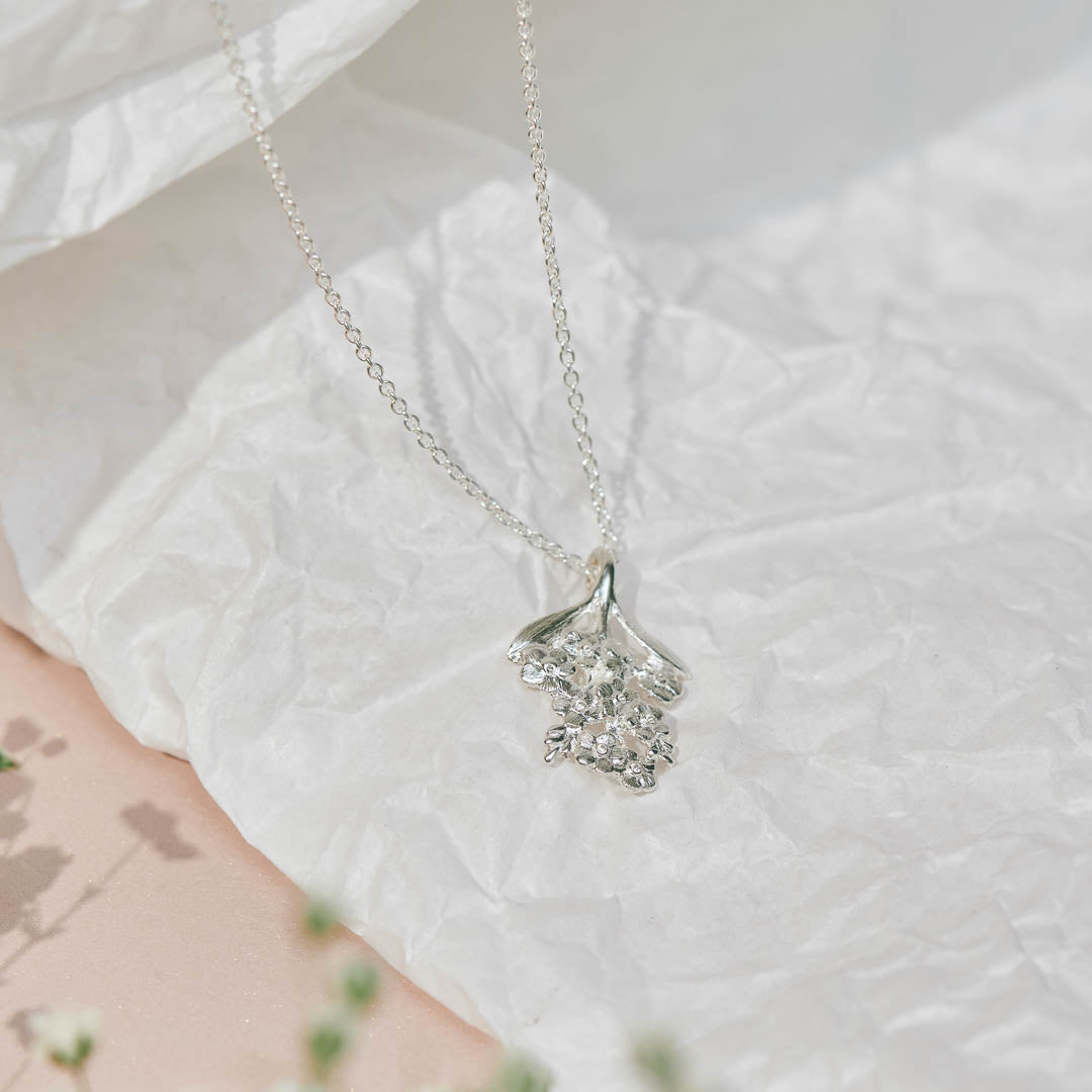 Forget-Me-Not flower inspired pendant with leaf detail, manufactured in sterling silver, and on a sterling silver rolo chain