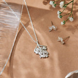 Forget-Me-Not flower inspired pendant with leaf detail, manufactured in sterling silver, and on a sterling silver rolo chain, photographed with the Forget-Me-Not studs