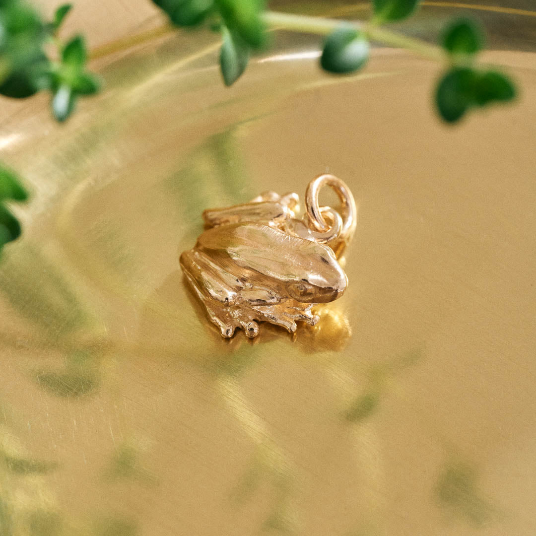 A miniature yellow gold frog jewellery charm.