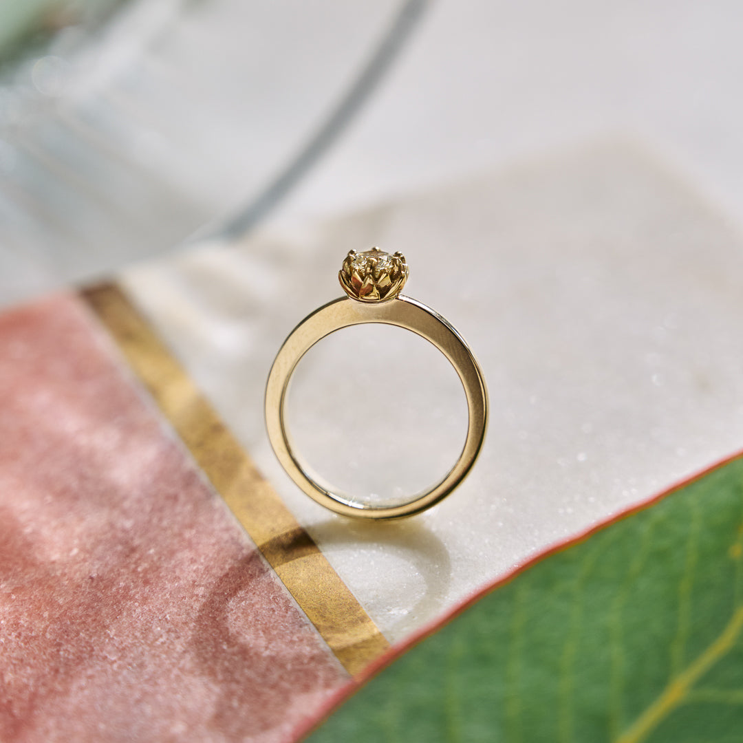 Gold ring with a diamond on a textured surface
