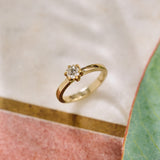 Gold ring with a diamond on a soft, blurred background
