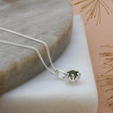 Dark green tourmaline gemstone set in a silver King Protea pendant on a silver rolo chain.