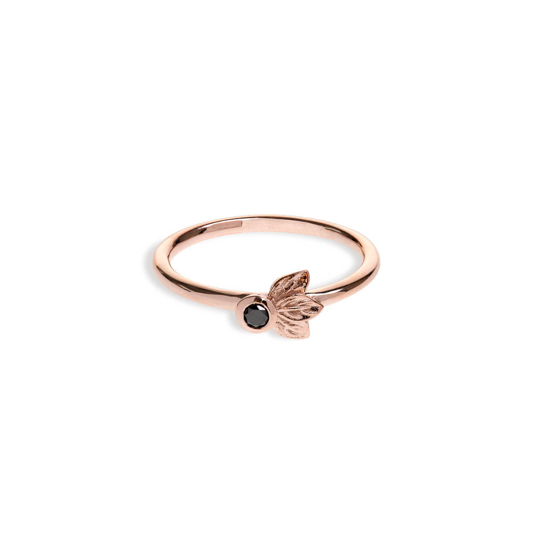 Black diamond in a classic tube setting on a rose gold ring with three leaf details