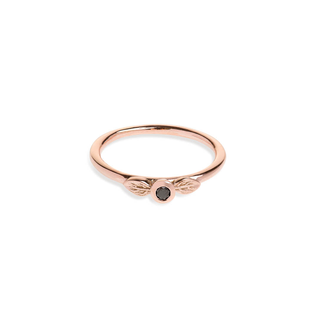 Black diamond in a classic tube setting on a rose gold ring with two leaf details