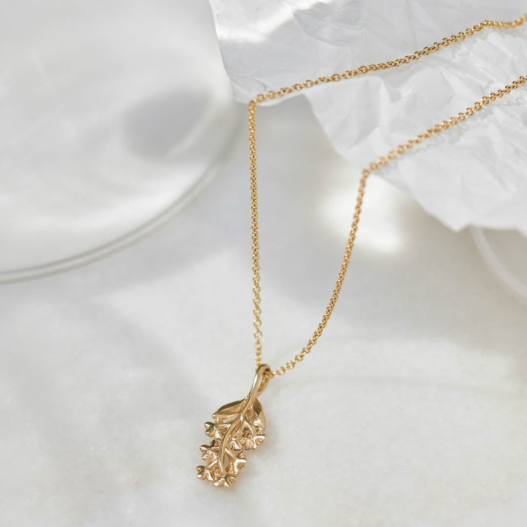 Back view of the Sapphire Forget-Me-Not Pendant showing the stem and leaf details