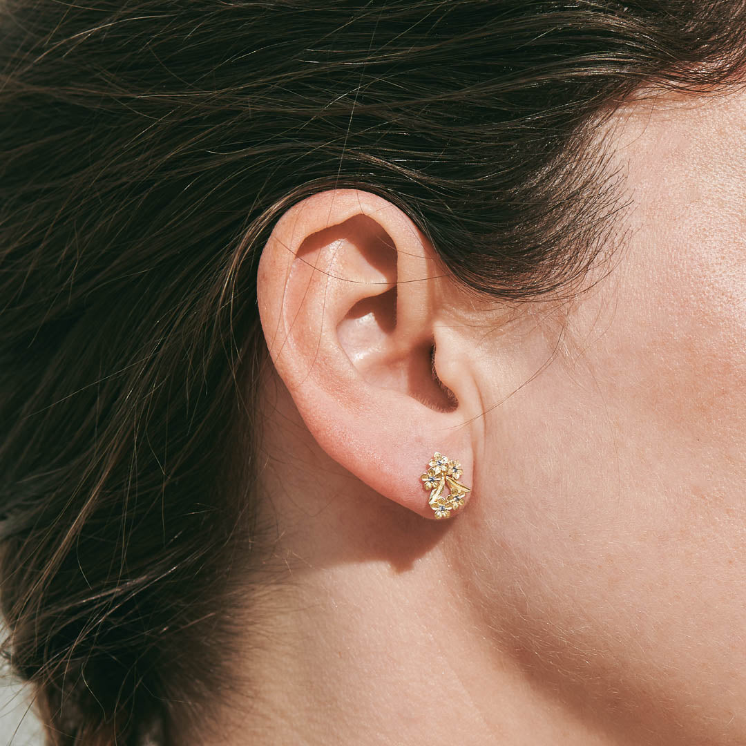 Forget-Me-Not Flower inspired studs with leaf details manufactured in 9ct yellow gold and set with light blue sapphires