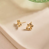 Forget-Me-Not Flower inspired studs with leaf details manufactured in 9ct yellow gold and set with light blue sapphires