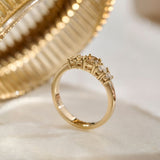 Side view of solid gold ring with a double gallery, four claw setting holding one central fancy brown diamond, known as a champagne diamond, flanked by four colourless natural diamonds tapering down in size. 