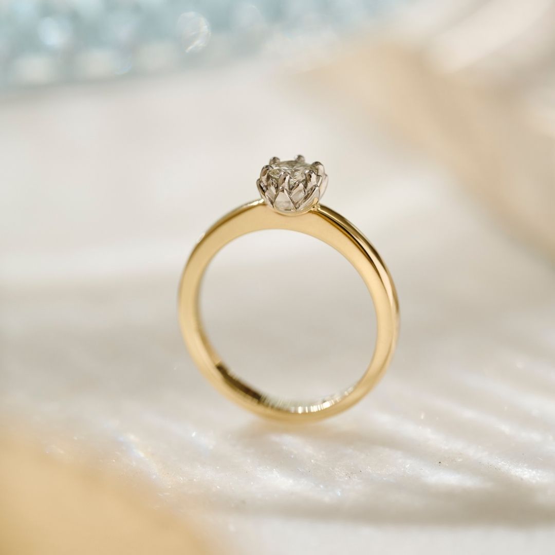 side view of the Two tone Botanica Protea Ring with a solid platinum protea petal setting and a yellow gold shank, this view shows the detail of the petals in the setting and the rounded gold shank. 