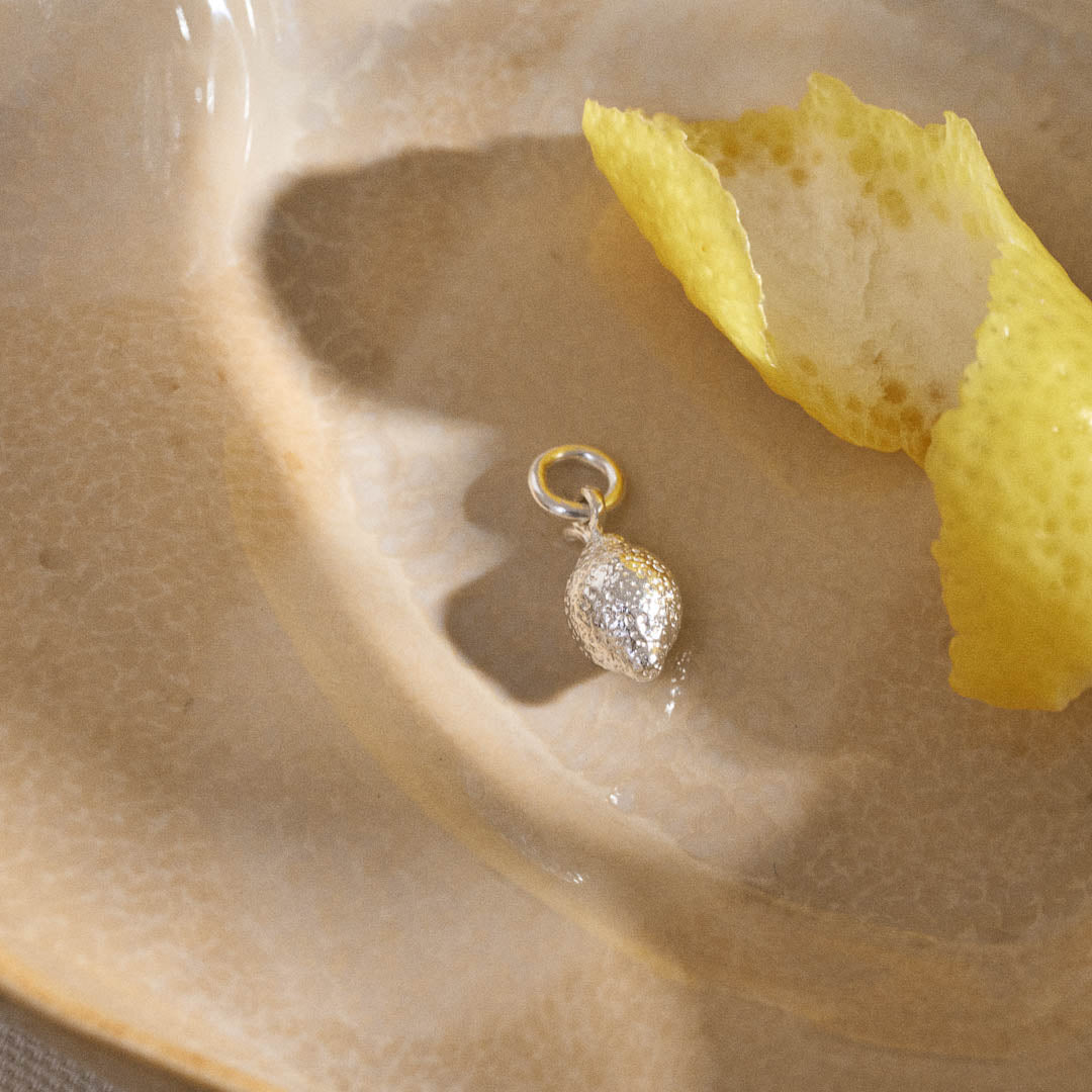 A miniature lemon jewellery charm in silver.