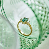A beautiful teal tourmaline that reminded us of the ocean flanked by two natural diamonds set in a design that is classic and timeless