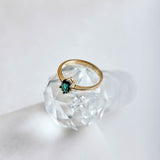 An oval green tourmaline set in a 9ct yellow gold ring with six claws