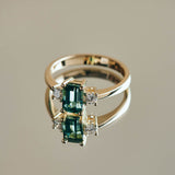 A beautiful teal tourmaline that reminded us of the ocean flanked by two natural diamonds set in a design that is classic and timeless