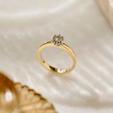 Two tone Botanica Protea Ring with a solid platinum protea petal setting and a yellow gold shank. Set with a natural colourless diamond, photographed on a textured white surface.