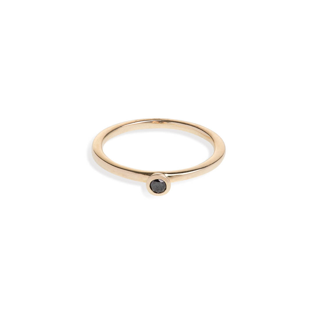 Black diamond in a classic tube setting on a yellow gold ring