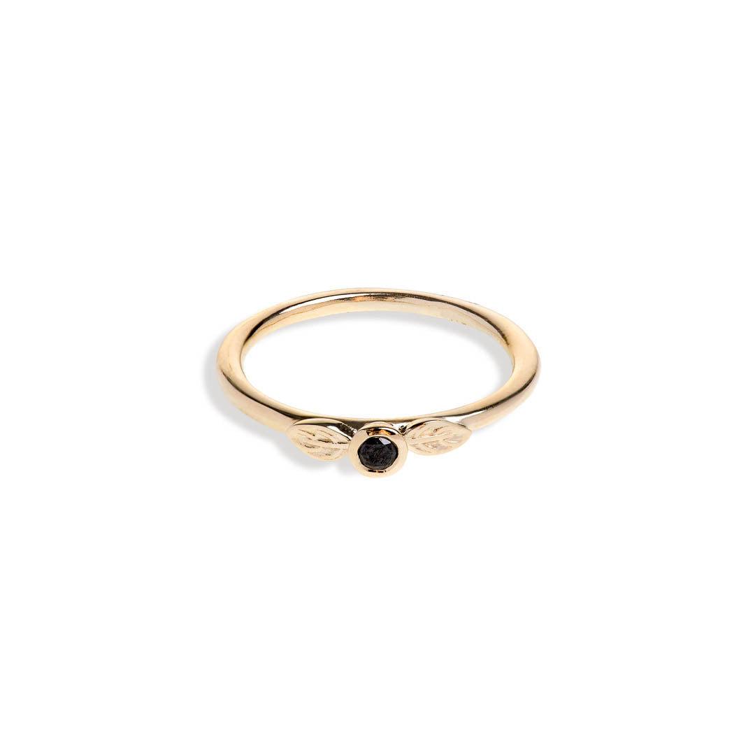 Black diamond in a classic tube setting on a yellow gold ring with two leaf details