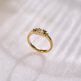 Yellow gold cluster ring set with a central natural diamond and additional blue, green, and yellow sapphires on either side. on a white background with subtle shadows.